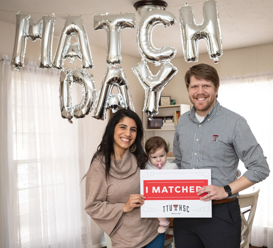 family standing in front of match day balloons