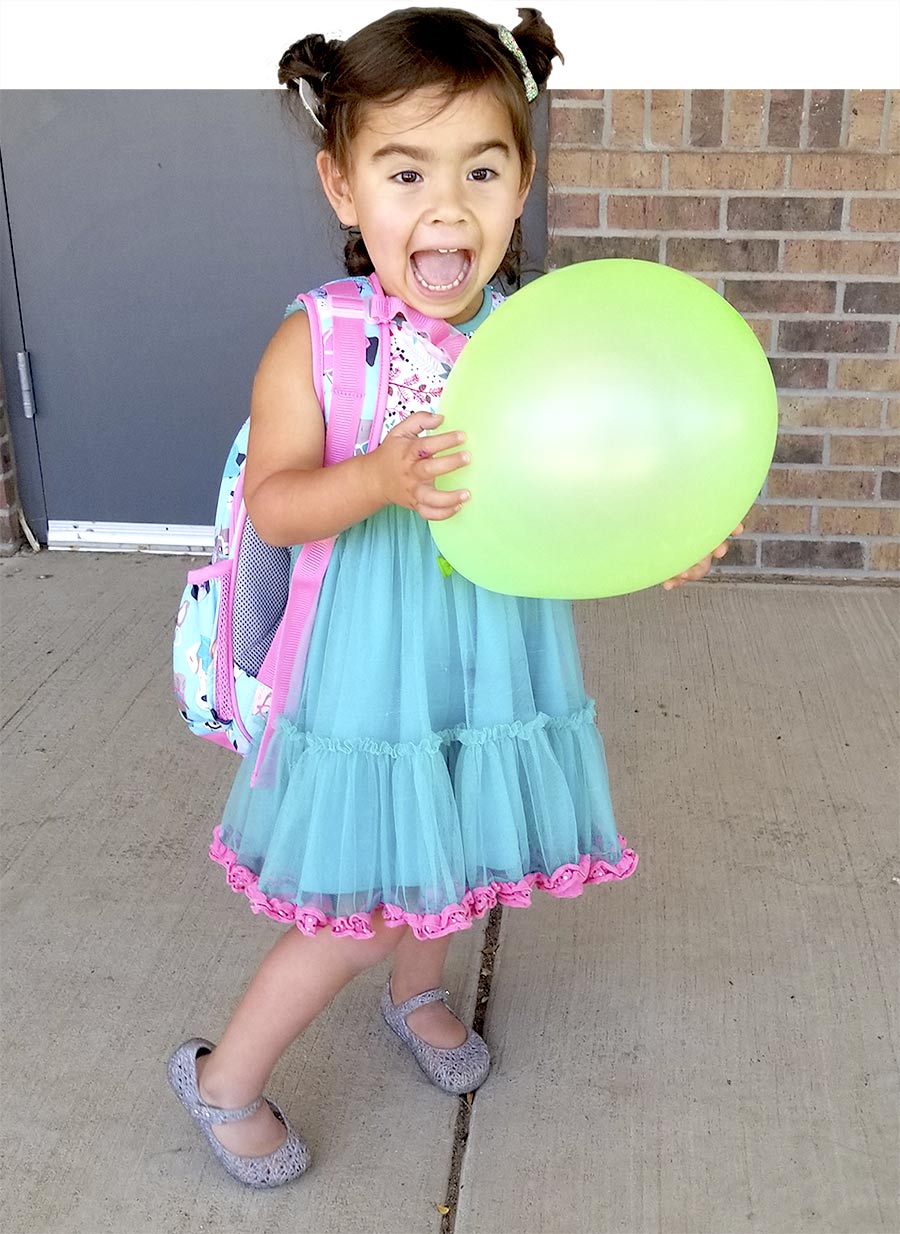 Eleanor Smith at Tech Tykes summer therapy program, holding a balloon and smiling