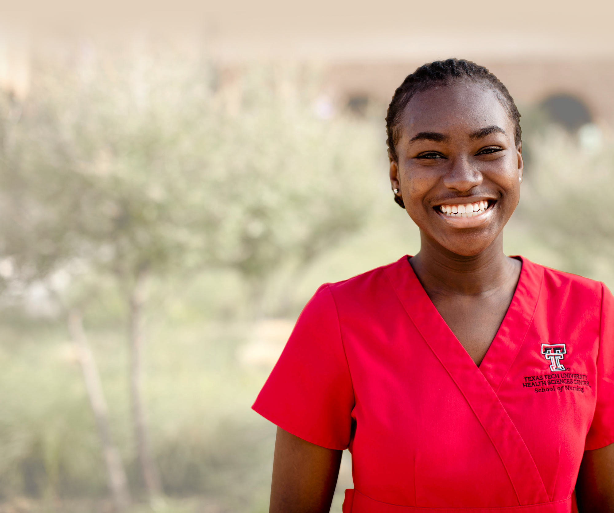 a young woman smiles wearing a Texas Tech University, School of Nursing uniform