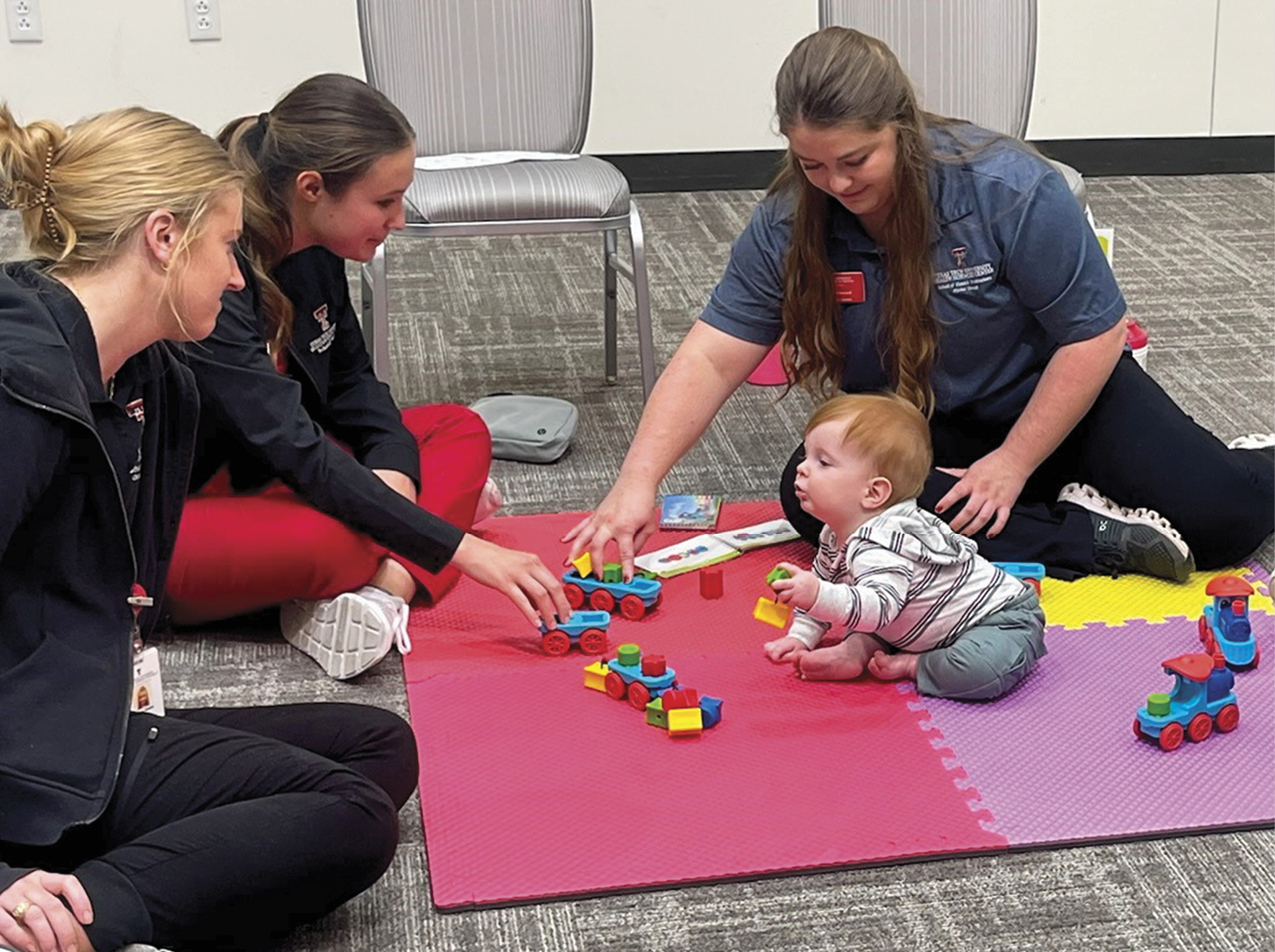 TTUHSC students playing with toddler at event