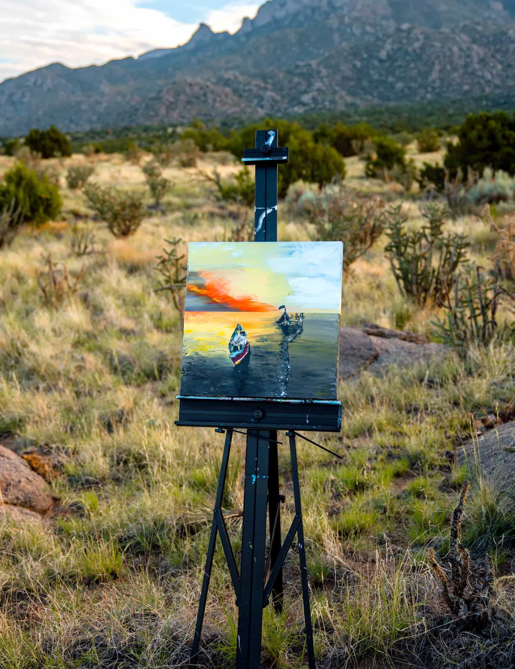 a painting sits on an easle among chaparral and vegetation