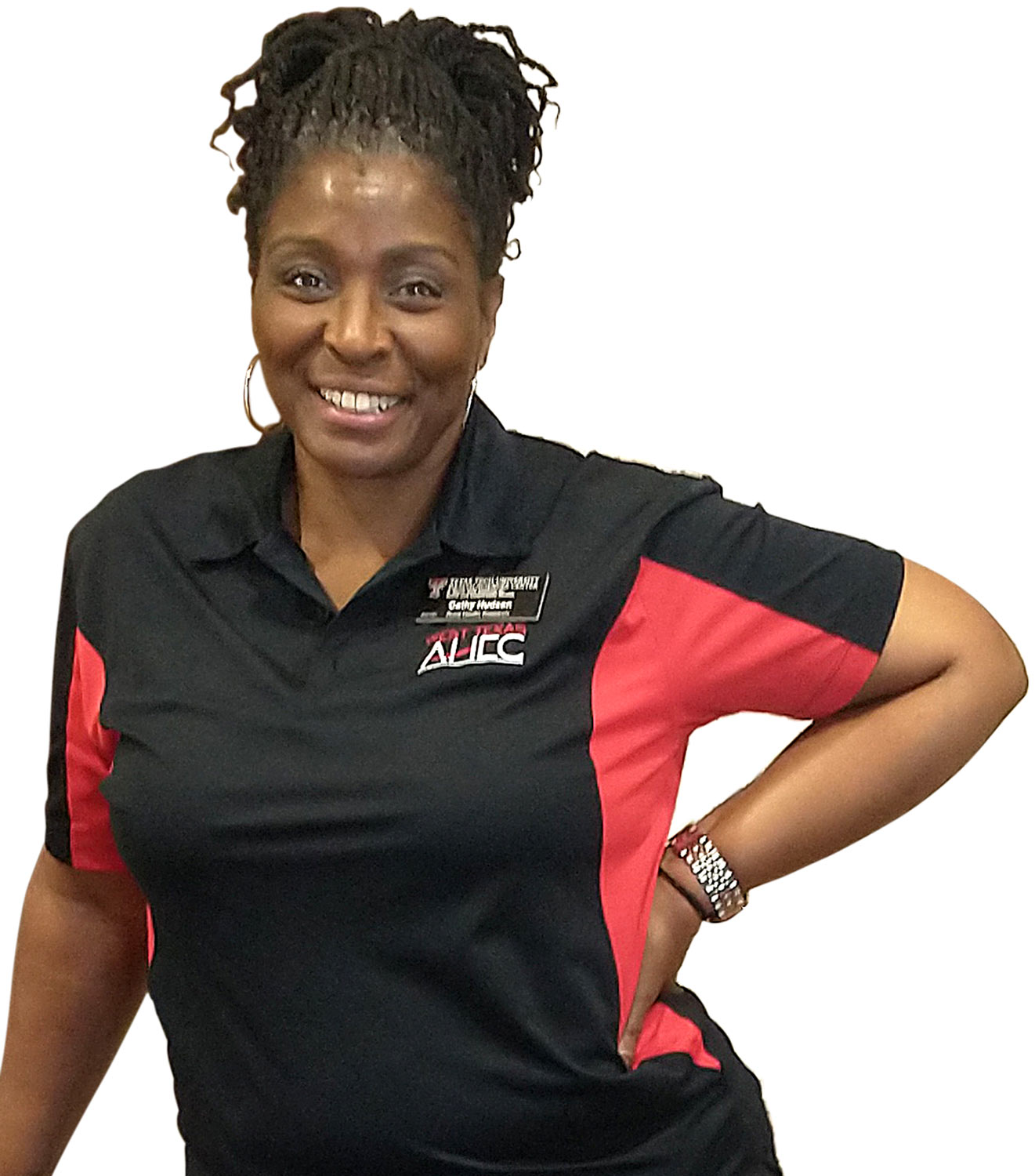 a woman wearing a Texas Tech shirt and name tag smiles with her hand on her hip