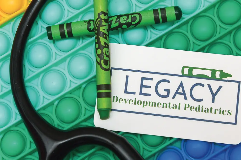 Green crayons and pop its with card that says Legacy Developmental Pediatrics