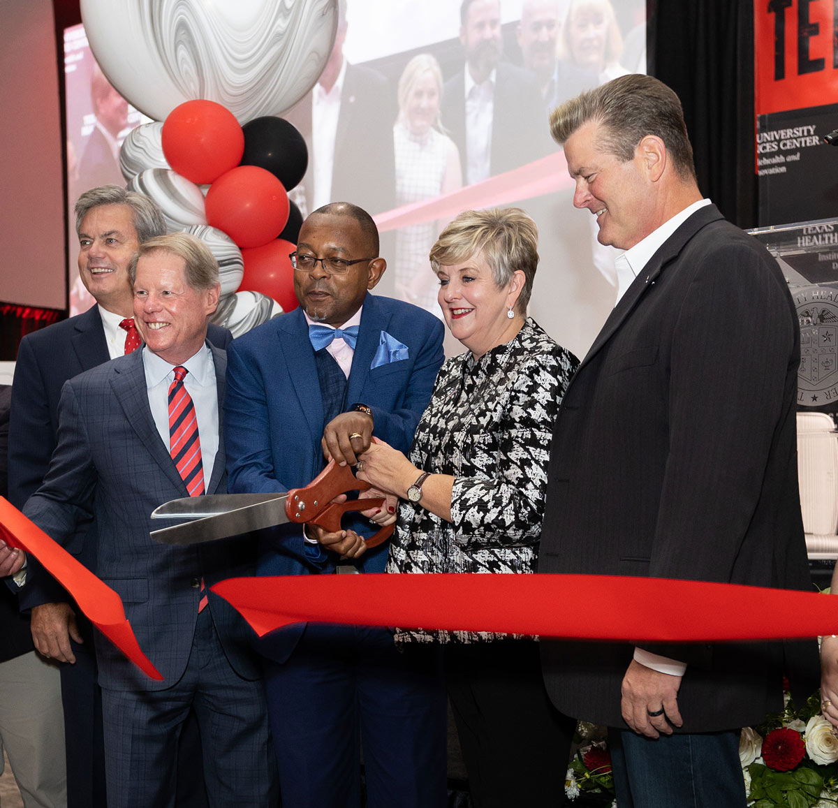 Lori Rice-Spearman participating in a ribbon cutting ceremony with Executive director for the Institute of Telehealth and Digital Innovation John Gachago.