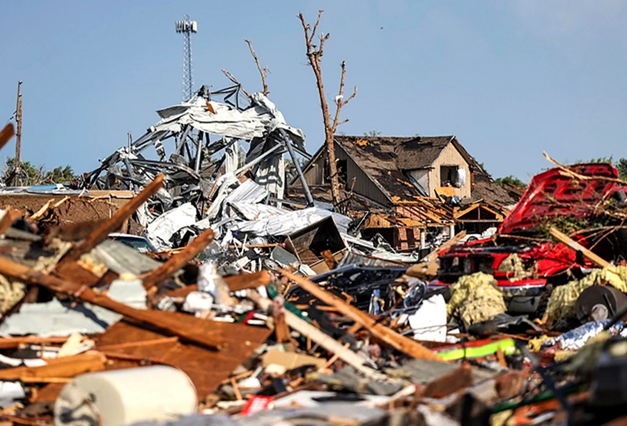 tornado rubble with house in background