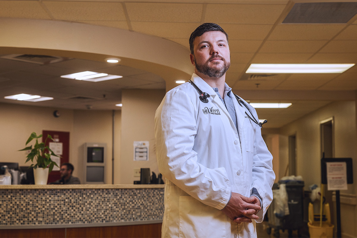 Blake DeWitt in lab coat in office