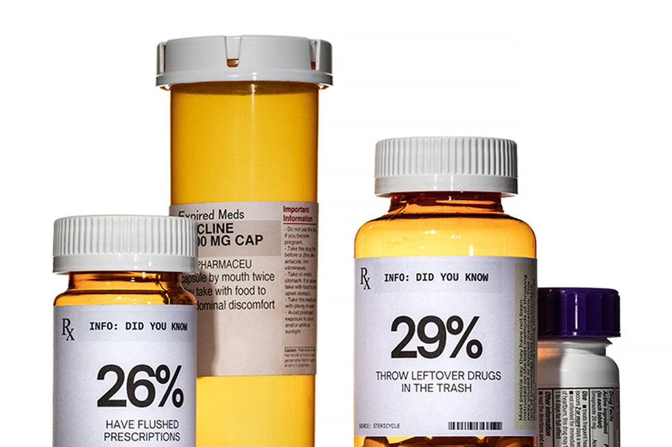 close up of two medicine cabinet shelves against a flat white background, in the center of both shelves are four various sized bottles of pills and liquid medication with label listing disposal percentage