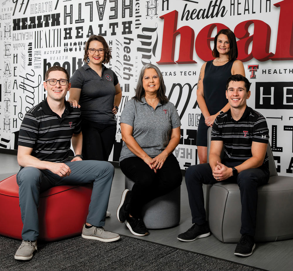 members of the Thompson family who work in pharmacy, posing in front of a wall covered with the word 'health' in different typefaces