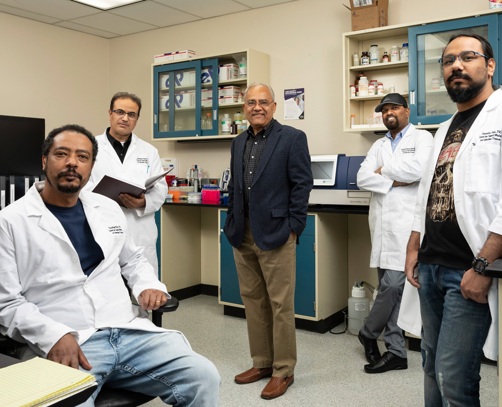 Afzal A. Siddiqui surrounded by other doctors in lab coats