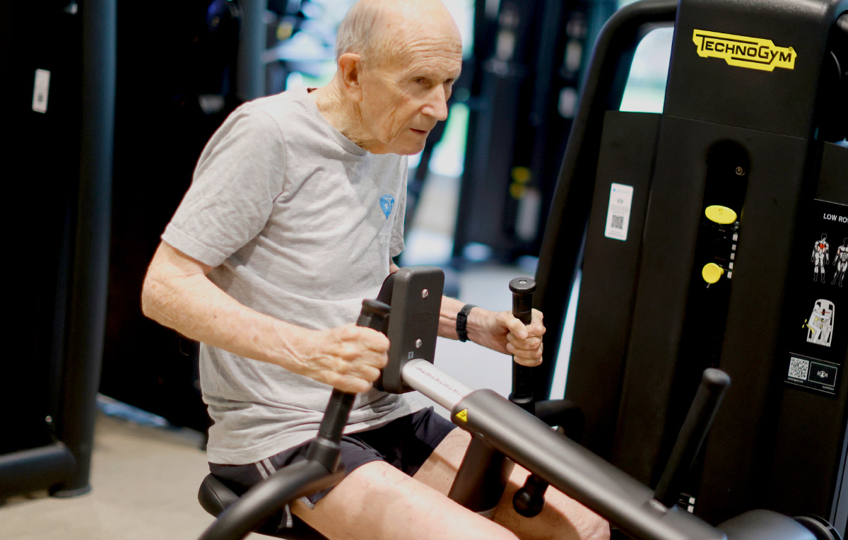 Kenneth using rowing machine at gym