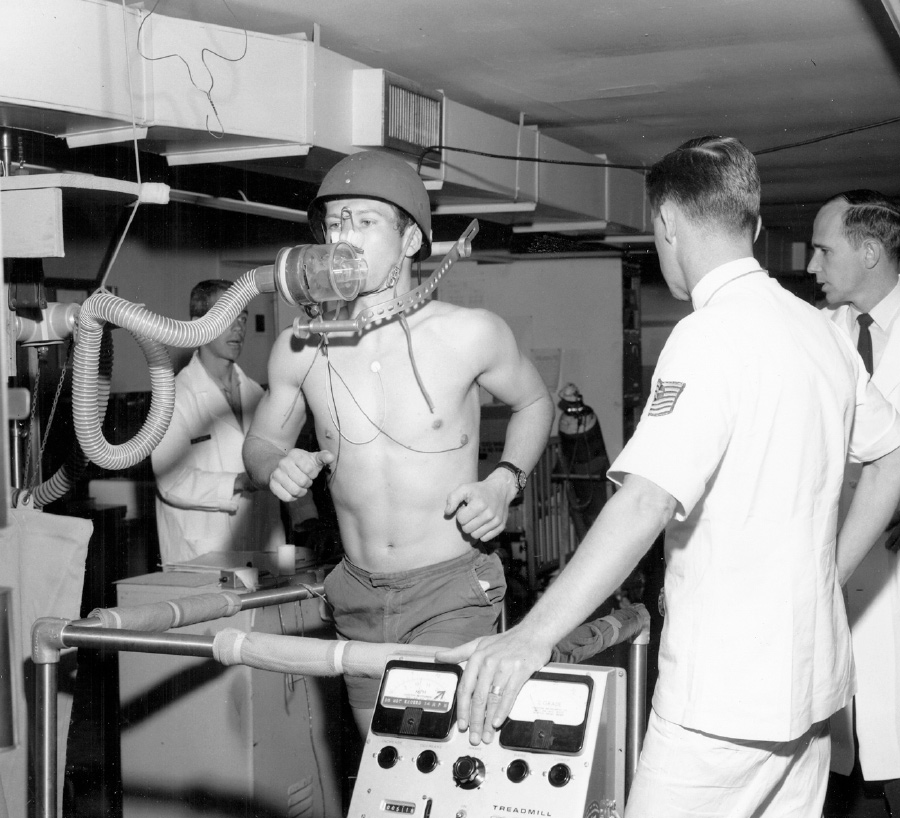 black and white photo of a young Kenneth doing a health assessment on a treadmill
