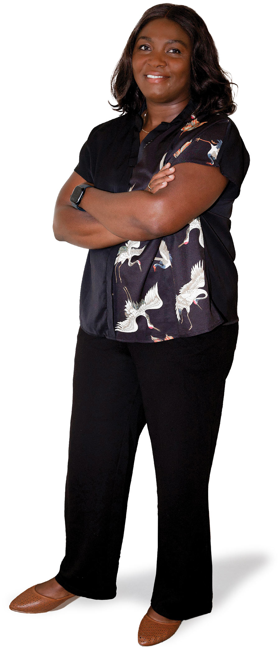 Full-length portrait of a smiling woman standing with arms crossed, wearing a black blouse featuring a flying crane pattern, black pants, and brown flats.